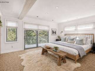 This stunning bedroom offers a serene retreat with its bright, airy design and natural light.