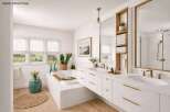 This luxurious bathroom boasts a modern design with a freestanding bathtub, double vanity, and ample natural light.