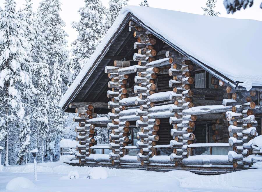 This stunning log cabin, nestled in a snowy landscape, offers a unique blend of rustic charm and modern comfort.
