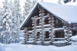 This stunning log cabin, nestled in a snowy landscape, offers a unique blend of rustic charm and modern comfort.