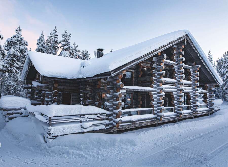 Experience the charm of a cozy log cabin nestled in a winter wonderland.