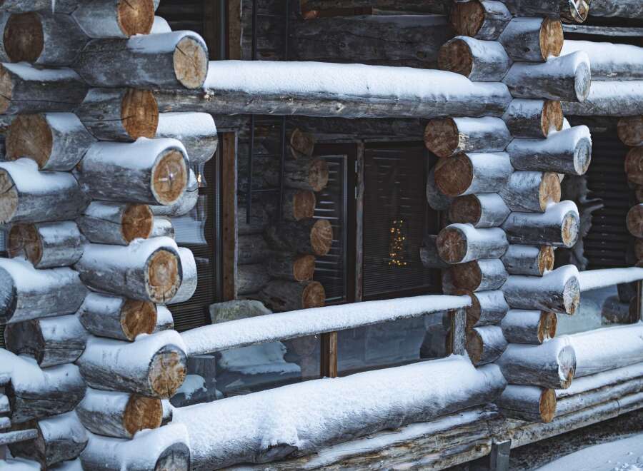 This charming log cabin exudes rustic elegance, perfect for a cozy winter retreat.