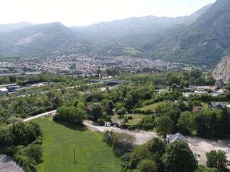 Discover a stunning property nestled in a picturesque valley, offering breathtaking views of the surrounding mountains and a charming town.
