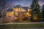 This stunning property boasts a beautiful exterior with a well-manicured lawn and mature trees.