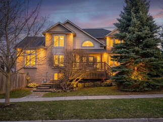 This stunning property boasts a beautiful exterior with a well-manicured lawn and mature trees.