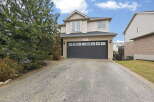This stunning two-story home boasts a charming exterior and a spacious driveway.