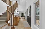 Step into luxury with this stunning entryway featuring a grand staircase and elegant hardwood details.