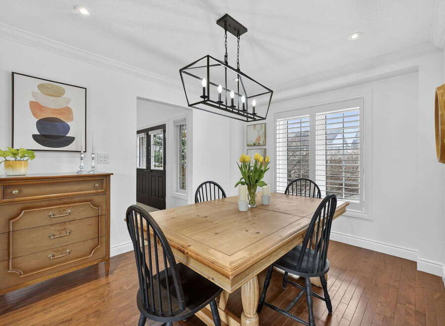 This stunning dining room features a beautiful wooden table and chairs, perfect for hosting family gatherings.