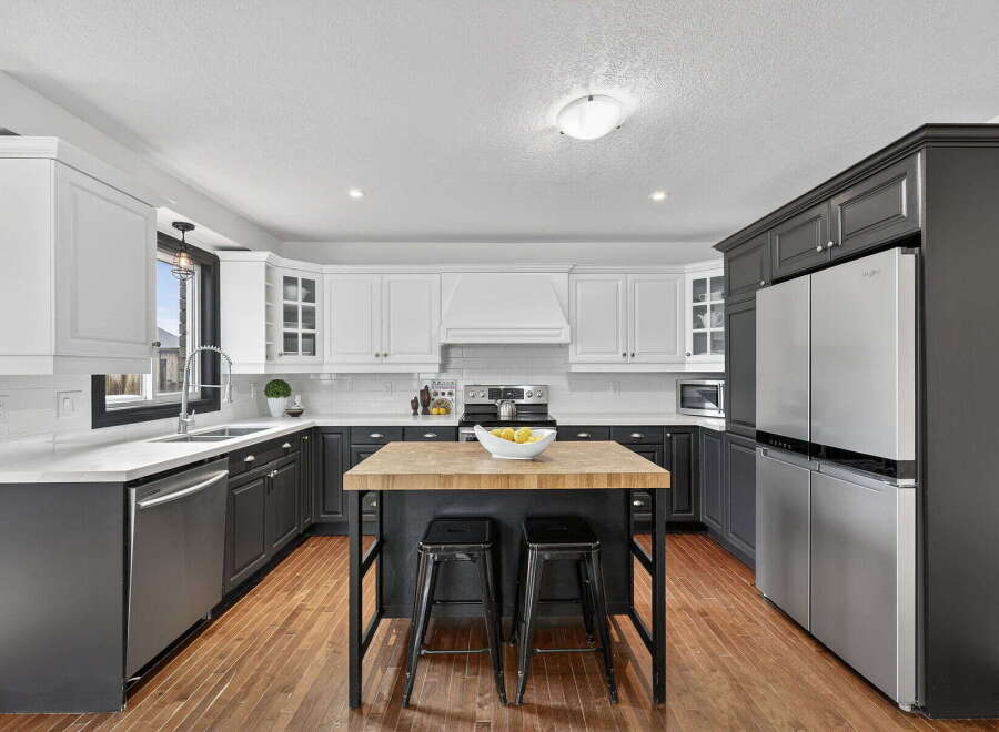 This stunning kitchen boasts a modern design with sleek black and white cabinetry, creating a sophisticated and inviting atmosphere.