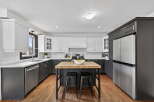 This stunning kitchen boasts a modern design with sleek black and white cabinetry, creating a sophisticated and inviting atmosphere.