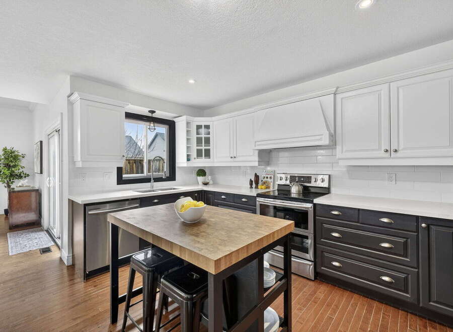 This stunning kitchen boasts a modern design with sleek white cabinetry and contrasting black accents.