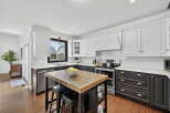 This stunning kitchen boasts a modern design with sleek white cabinetry and contrasting black accents.