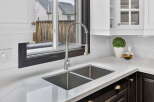 This stunning kitchen boasts a modern design with sleek countertops and a stainless steel sink.