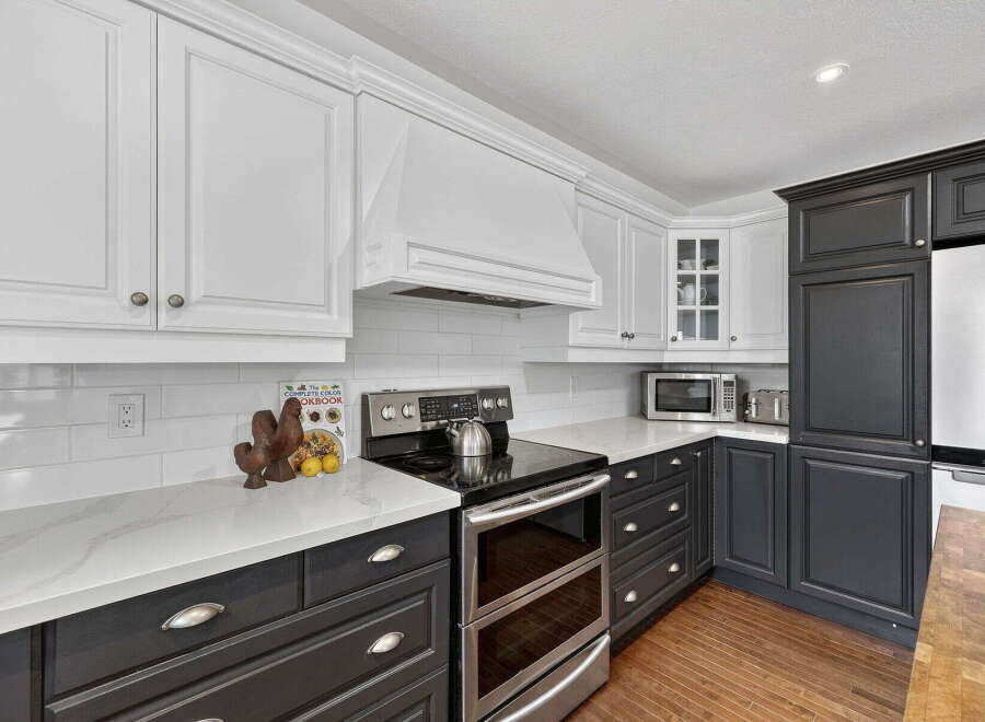 This stunning kitchen boasts a modern design with sleek white and dark gray cabinetry, creating a sophisticated contrast.
