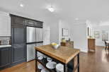 This stunning kitchen boasts a modern design with sleek stainless steel appliances and dark cabinetry.