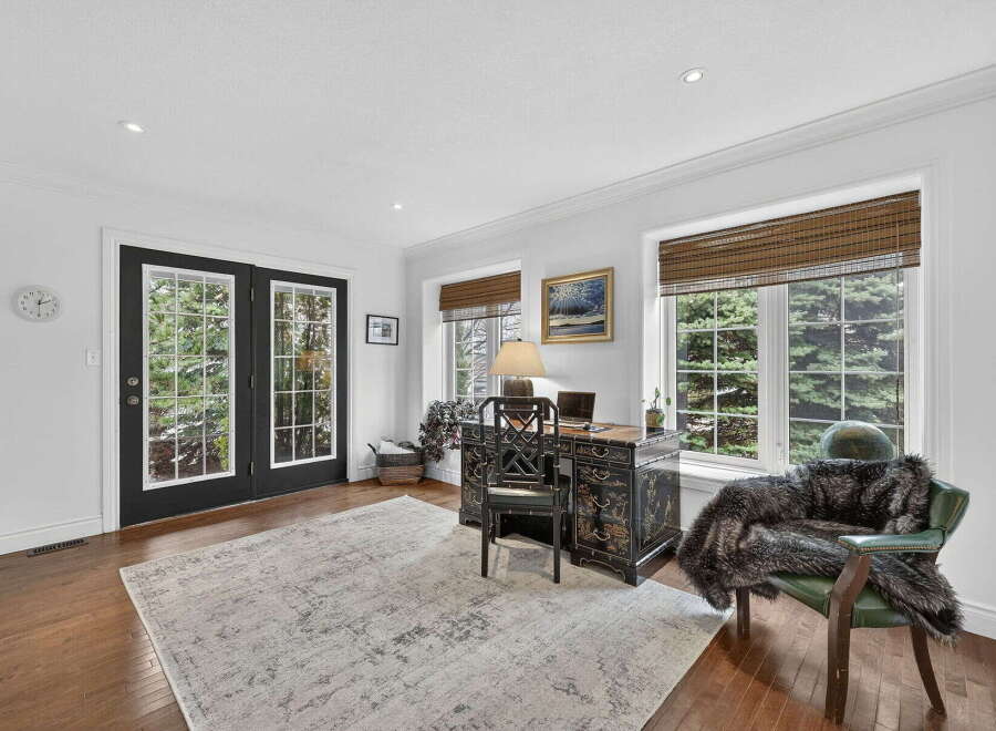 Step into this elegant home office, bathed in natural light from the large windows.