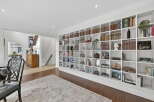 This stunning property boasts a custom-built bookshelf that spans an entire wall, perfect for showcasing your literary collection and adding a touch of elegance to the living space.