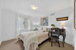 Step into this charming bedroom, featuring a cozy bed and a stylish desk.