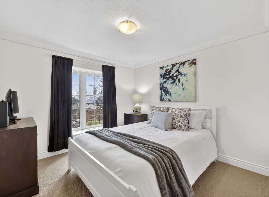 Step into this inviting bedroom, featuring a bright and airy ambiance with its pristine white walls and ample natural light.