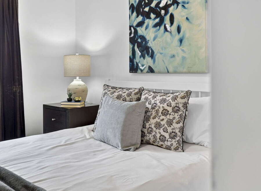 This cozy bedroom features a comfortable bed with stylish pillows and a serene atmosphere.