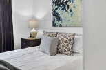 This cozy bedroom features a comfortable bed with stylish pillows and a serene atmosphere.