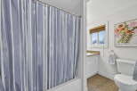 Step into this beautifully designed bathroom, featuring a stylish shower curtain with a modern striped pattern.