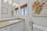 This charming bathroom features a bright and airy design with a large mirror and a stylish vanity.