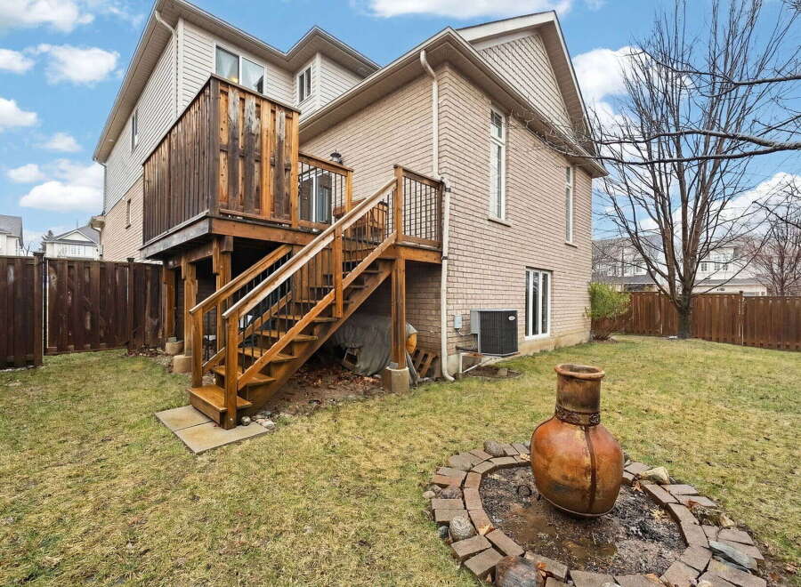 Enjoy outdoor living at its finest with this stunning property featuring a spacious wooden deck and a cozy fire pit.