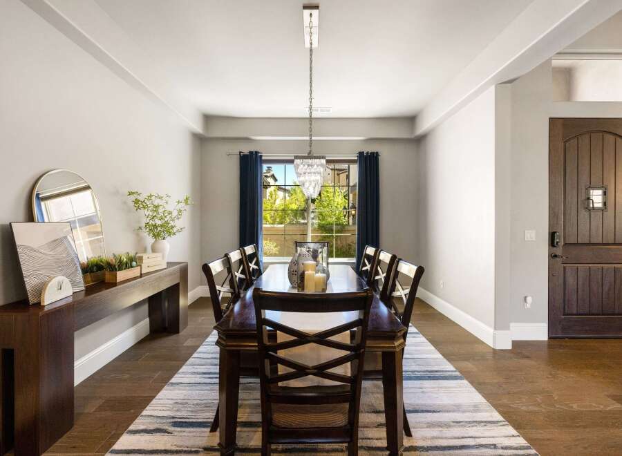 Step into luxury with this stunning dining room, featuring a beautiful chandelier and a long, elegant dining table.