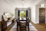 Step into luxury with this stunning dining room, featuring a beautiful chandelier and a long, elegant dining table.