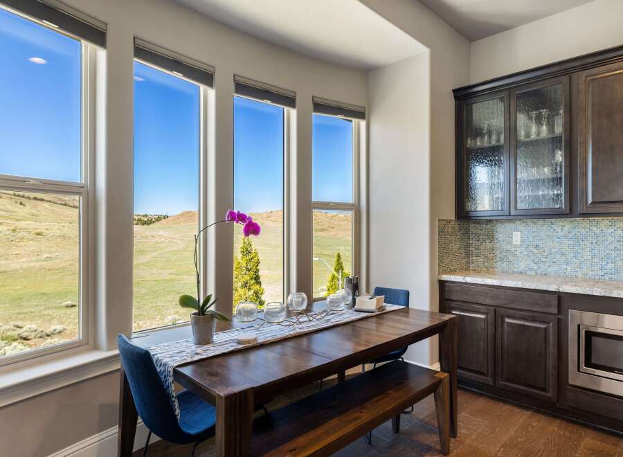 This stunning dining area boasts expansive windows that frame breathtaking views of the surrounding landscape.