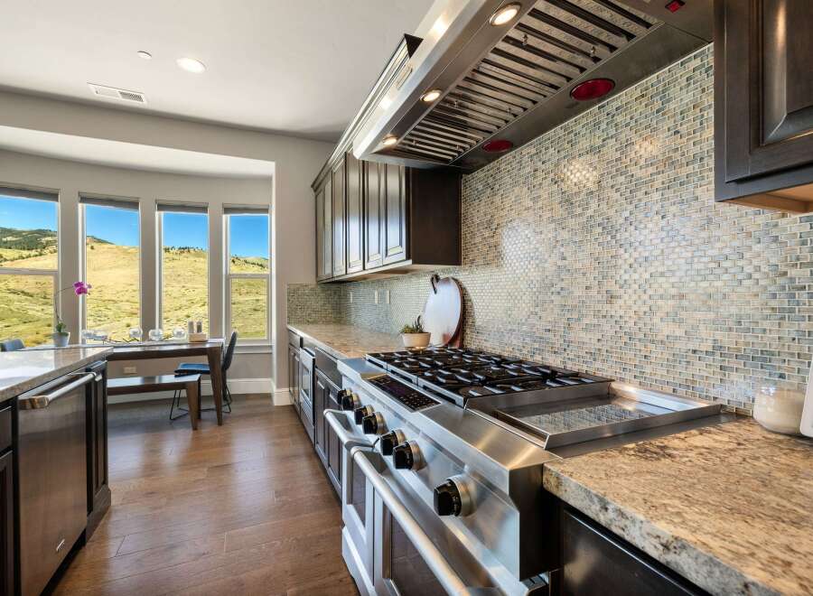 This stunning kitchen boasts high-end appliances and a beautiful tile backsplash.