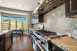 This stunning kitchen boasts high-end appliances and a beautiful tile backsplash.