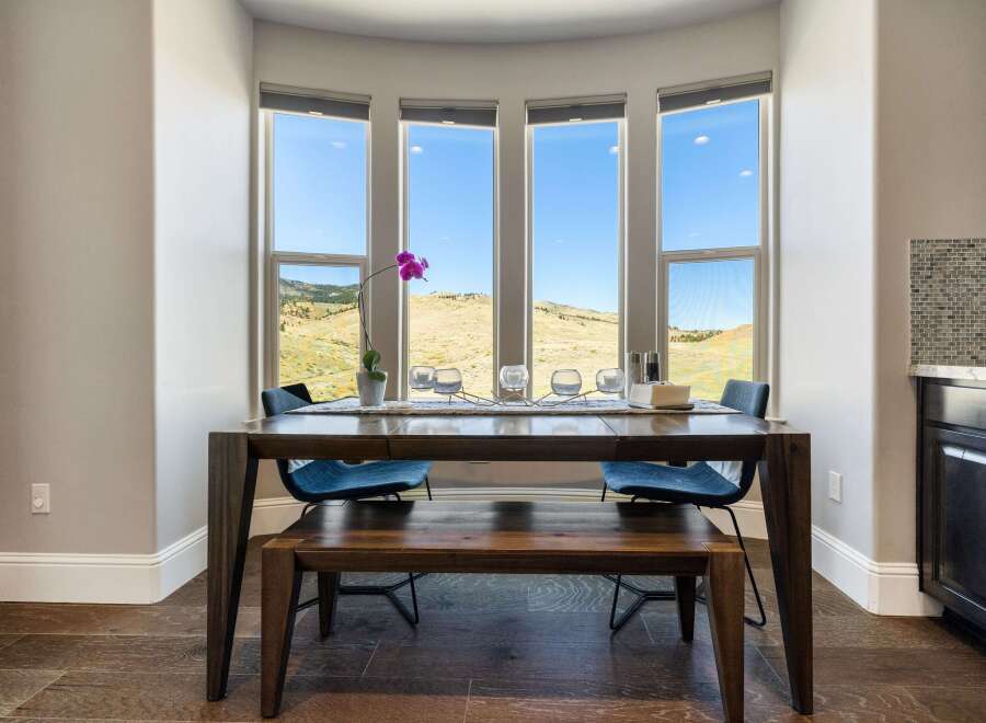 This stunning dining area features a large, dark wood table with seating for four, perfect for hosting gatherings.