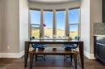 This stunning dining area features a large, dark wood table with seating for four, perfect for hosting gatherings.
