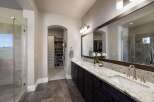 Step into luxury with this stunning bathroom, featuring a spacious walk-in shower and a double vanity with elegant granite countertops.