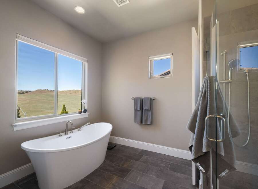 This luxurious bathroom boasts a modern design with a freestanding tub and a separate glass-enclosed shower.