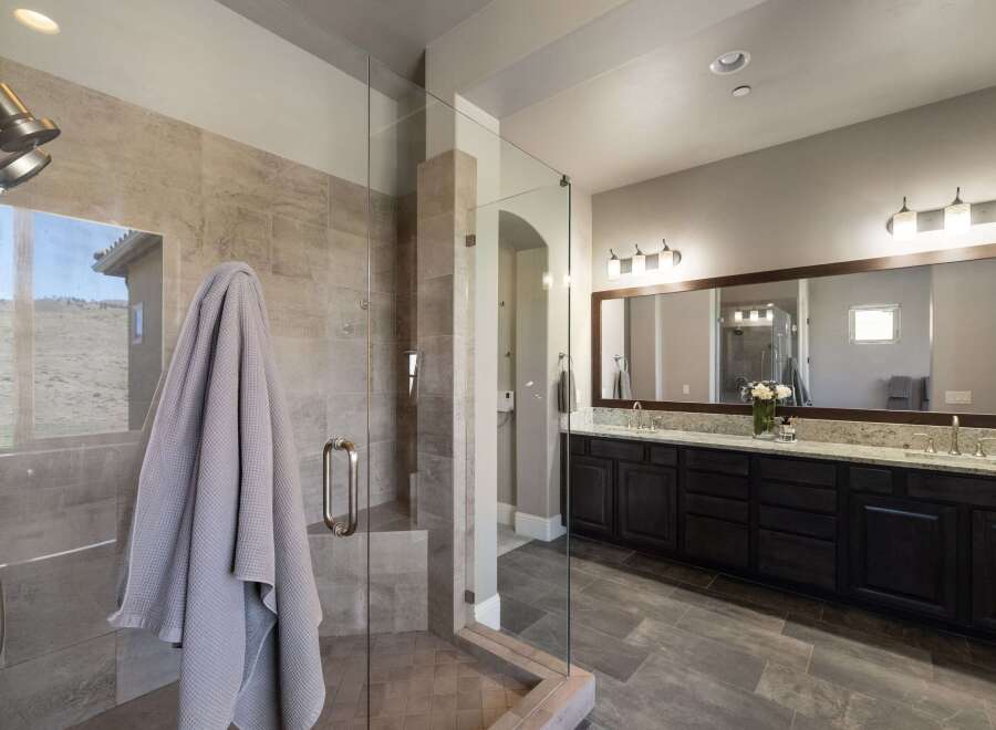Step into luxury with this stunning bathroom featuring a spacious walk-in shower with glass doors and elegant tile work.