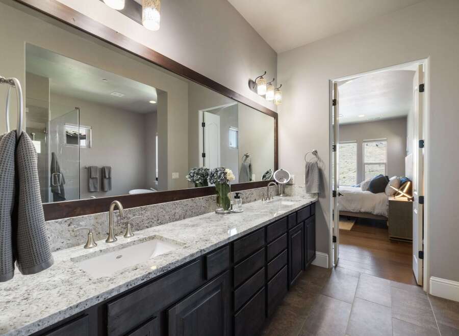 This stunning bathroom boasts a luxurious design with a spacious vanity and a large mirror, perfect for getting ready in style.