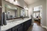 This stunning bathroom boasts a luxurious design with a spacious vanity and a large mirror, perfect for getting ready in style.