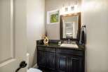 This stunning bathroom features a modern vanity with a dark granite countertop and sleek cabinetry.
