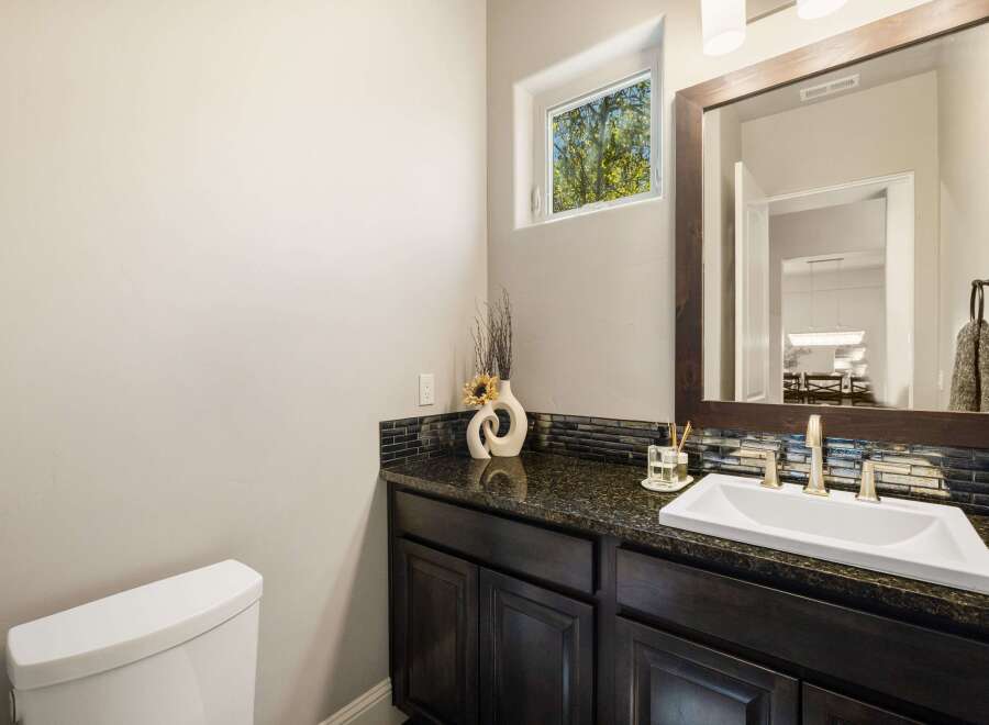 This stunning bathroom boasts a modern design with a sleek vanity and a beautiful granite countertop.