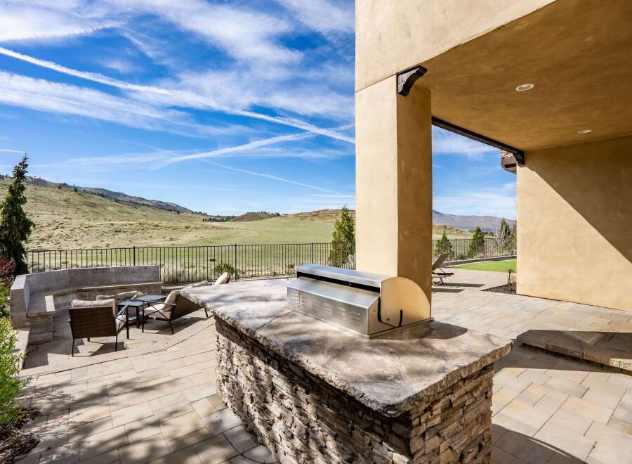 Enjoy outdoor living at its finest with this stunning property featuring a built-in grill and a spacious patio.