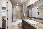 Step into this beautifully designed bathroom, featuring a modern vanity with a granite countertop and a sleek, undermount sink.