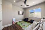 This inviting playroom is perfect for kids, featuring a vibrant play mat, comfortable seating, and a mounted TV for entertainment.