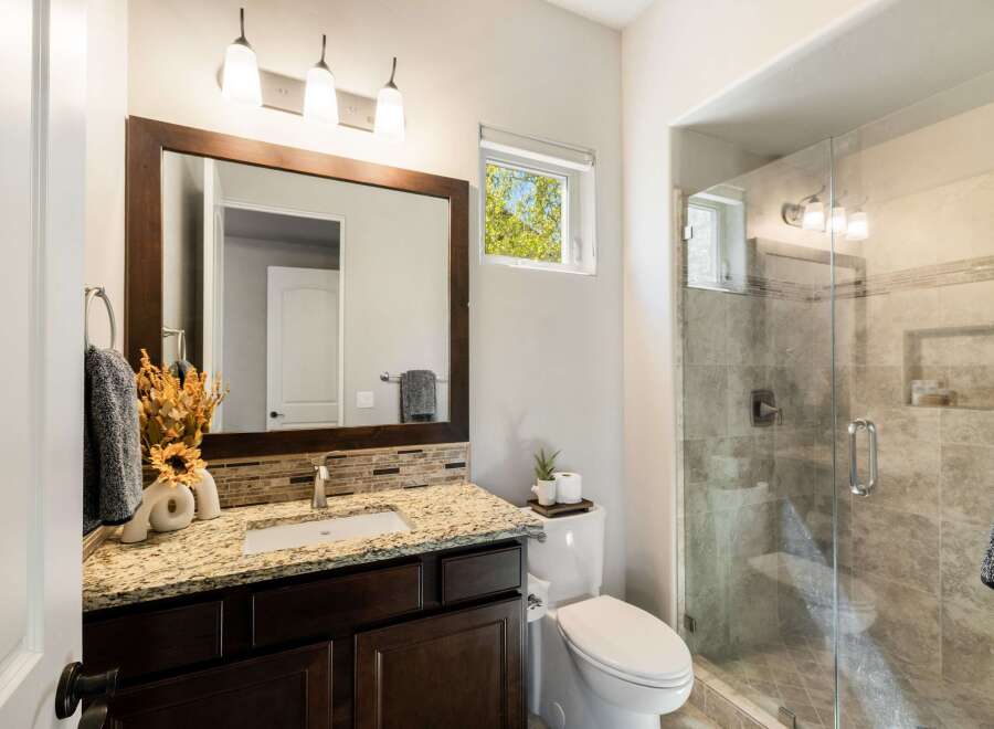 This stunning bathroom boasts a modern design with a spacious walk-in shower and elegant vanity.