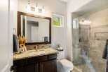 This stunning bathroom boasts a modern design with a spacious walk-in shower and elegant vanity.