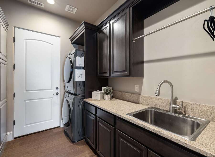 Step into this beautifully designed laundry room, featuring a modern stacked washer and dryer set.