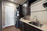 Step into this beautifully designed laundry room, featuring a modern stacked washer and dryer set.