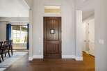 Step into this inviting entryway, showcasing a stunning wooden front door and elegant hardwood floors.